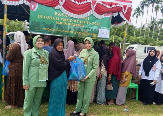 Ketua Persit KCK Cabang XIX Kodim 0102/Pidie dan Wakil Ketua Bhayangkari Polres Pidie Layani Warga di Bazar Murah TMMD ke-129