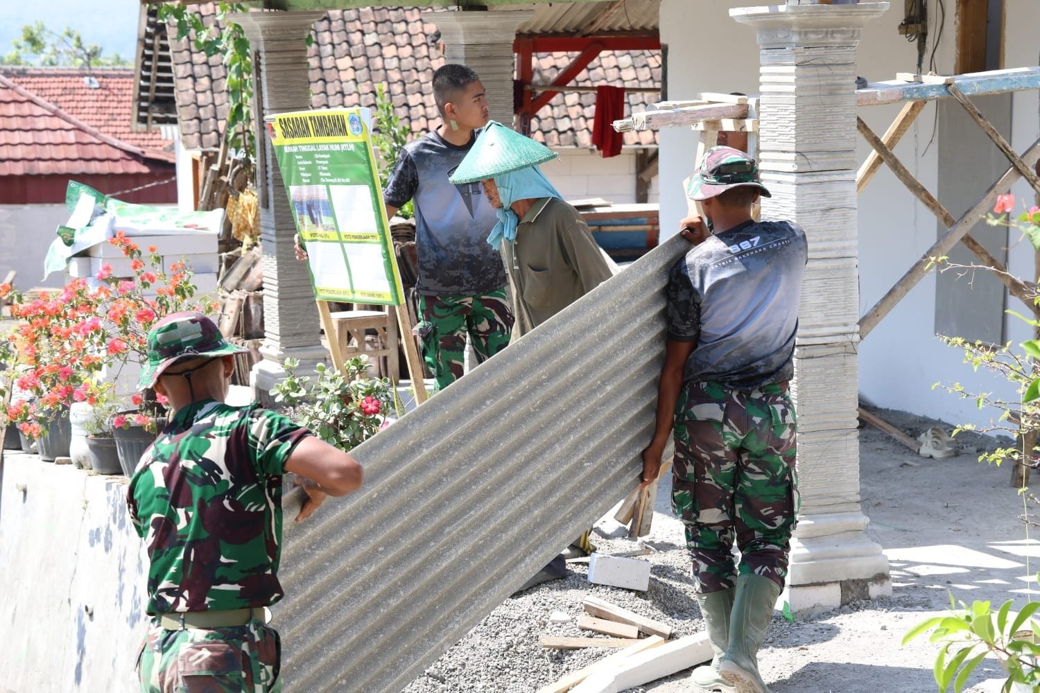 Sentuhan Hangat di Bawah Naungan Esbes: Anggota Satgas TMMD 129 Kodim 0812/Lamongan Bahu-Membahu Pasang Atap Teras Rumah Warga