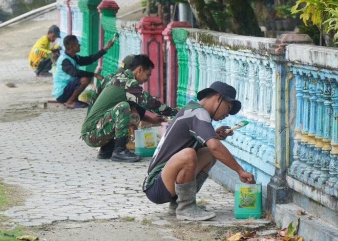 Satgas TMMD Bersama Warga Gotong Royong Cat Pagar di Desa Umbele