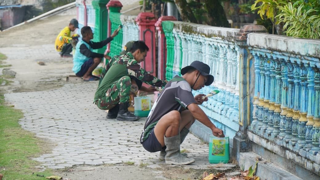 Satgas TMMD Bersama Warga Gotong Royong Cat Pagar di Desa Umbele