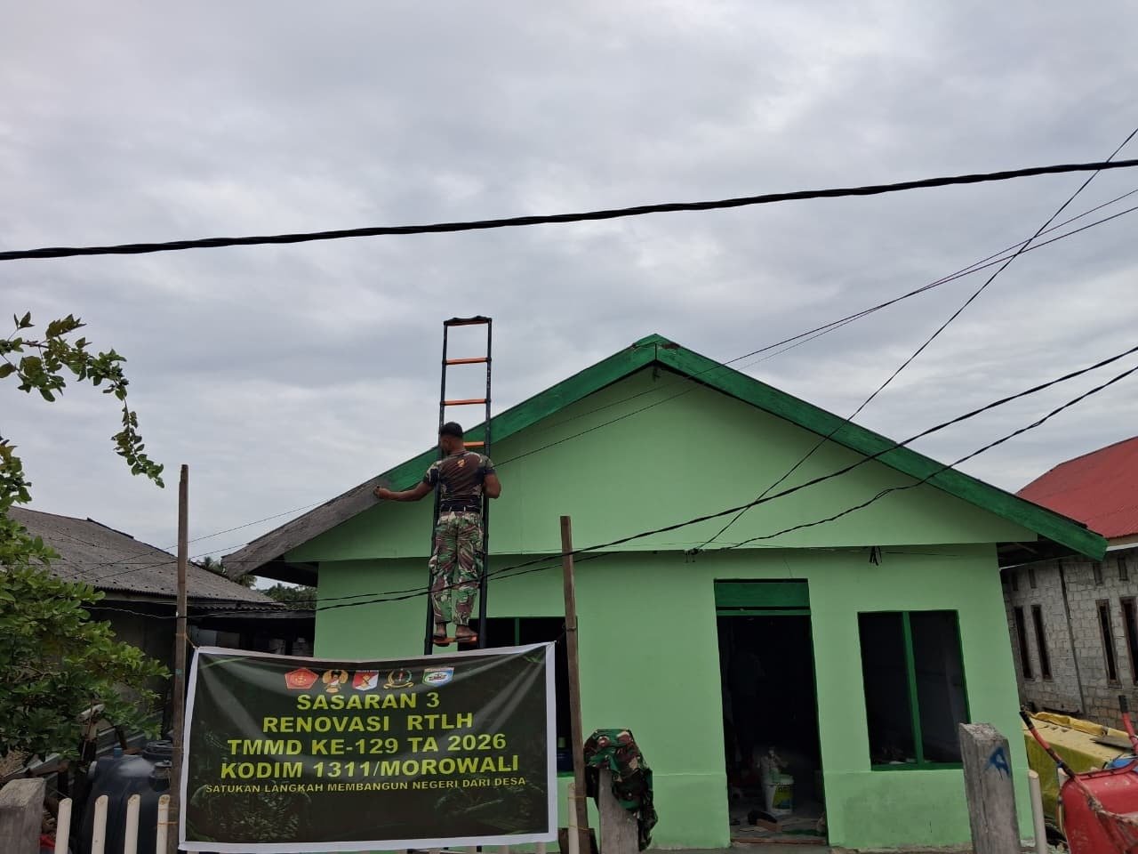 Satgas TMMD Ke-129 Lanjutkan Pengecatan Dinding Luar RTLH Milik Bapak Suhardin