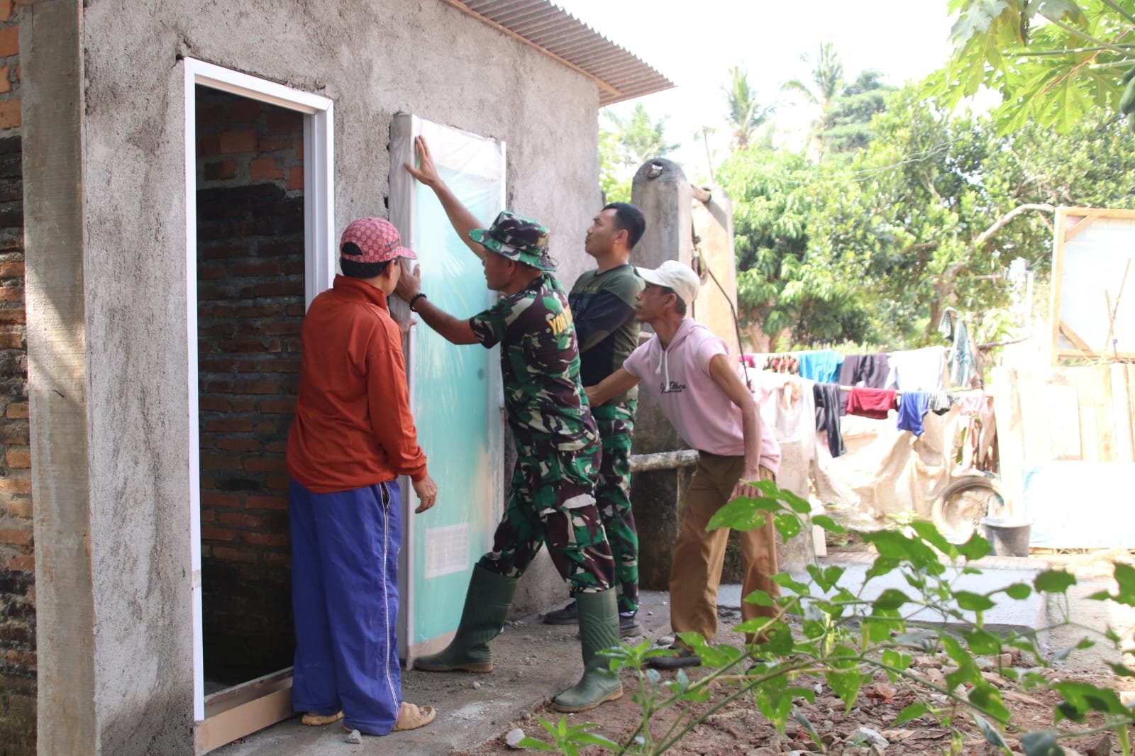 Wujud Kepedulian Satgas TMMD, Pemasangan Pintu MCK Libatkan Warga Sekitar