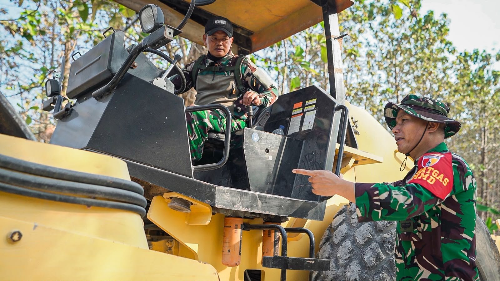 Pastikan kualitas pemadatan jalan, Dansatgas TMMD 129 Kodim 0812/Lamongan sambil menaiki Buldozer berinteraksi langsung dengan operator