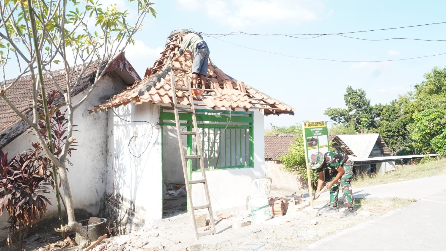 Wujudkan Keamanan Desa, Satgas TMMD 129 Kodim 0812/Lamongan dan Warga Tlemang Bahu-Membahu Pasang Atap Pos Kamling