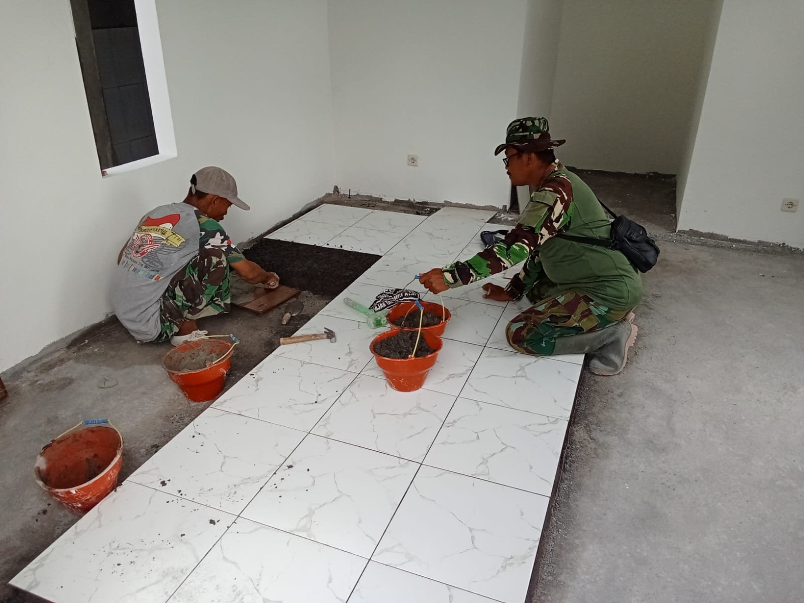 Tahap Finishing Dimulai, Satgas TMMD Kodim 0813/Bojonegoro Kerjakan Pemasangan Keramik Musala dan MCK