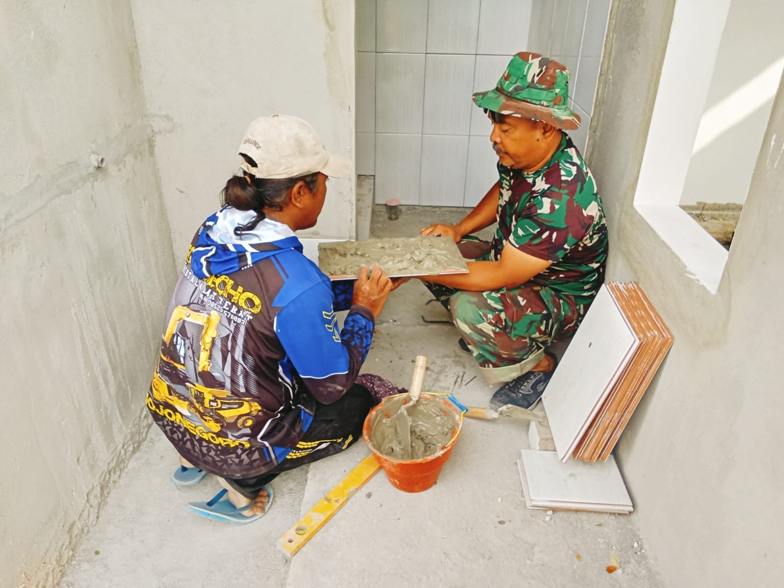 Pemasangan Keramik Jadi Fokus Satgas TMMD Ke-129 Kodim 0813/Bojonegoro di Musala dan MCK Kesongo–Sukorame