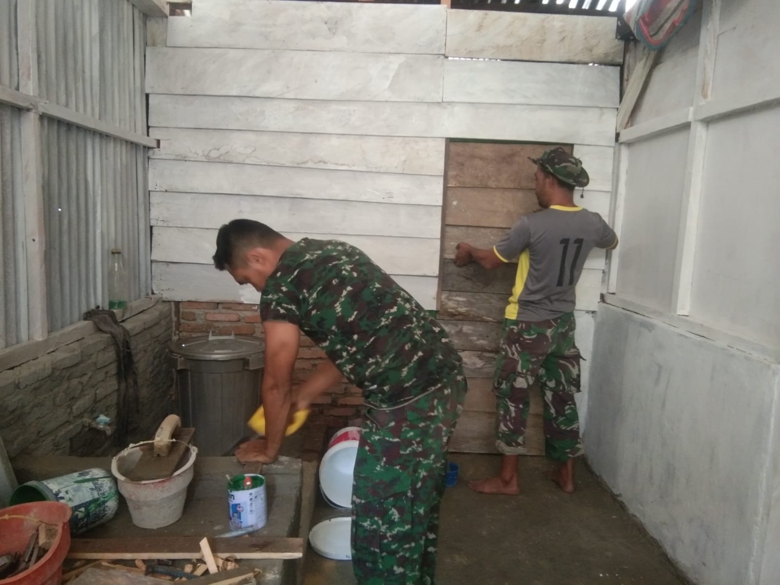 Pintu Kamar Mandi RTLH Bapak Bella dipasang oleh Serma Abidin dan TMMD