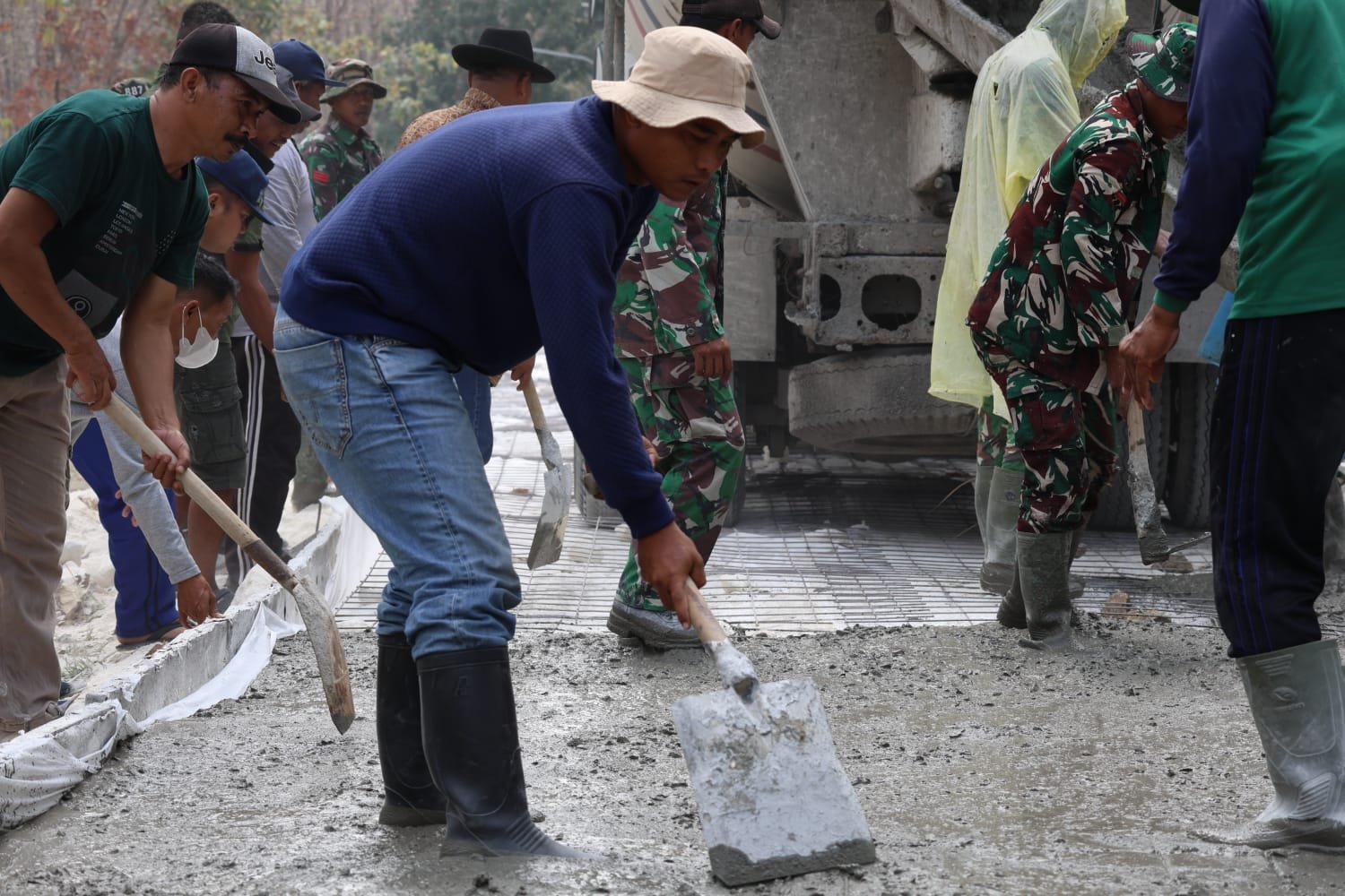 ​Momen Kemanunggalan: Bekerja Sama Tanpa Lelah, Warga Desa Tlemang Bahu-Membahu Ratakan Cor Jalan Program TMMD ke-129 Kodim 0812/Lamongan