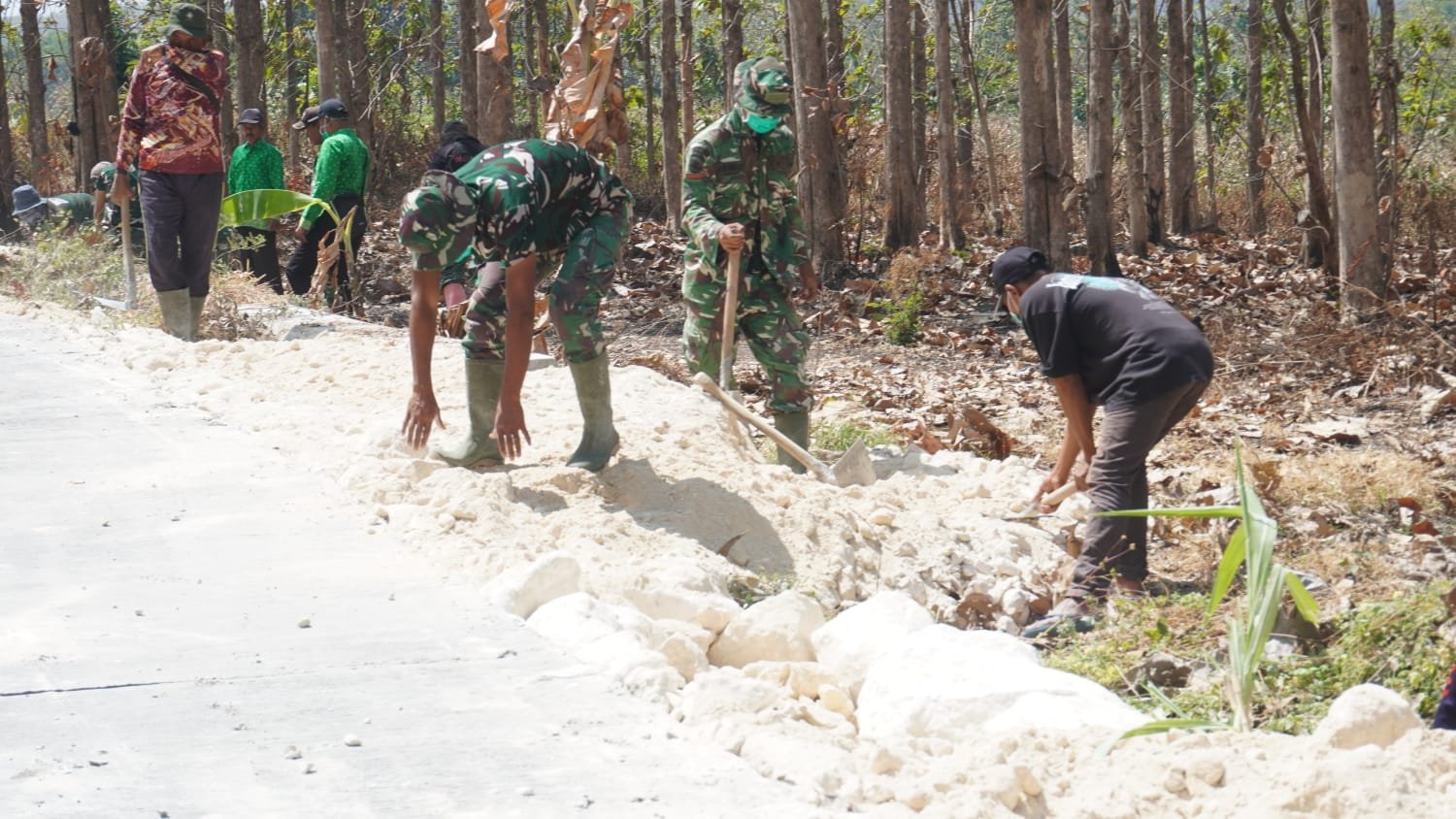 Perkokoh Bahu Jalan dan Keamanan Akses Desa, Satgas TMMD 129 dan Warga Uruk Sisi Jalan Rabat Beton Gunakan Padel