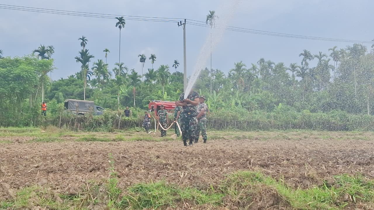 Cuaca Terik Tak Surutkan Semangat, Satgas TMMD Kodim 0102/Pidie Manfaatkan Armada Damkar TNI AD Siram Benih Jagung