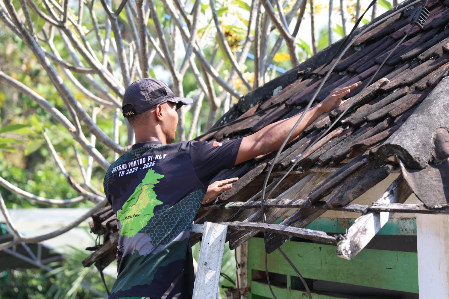 Abadikan Momen Presisi, Tim Penerangan Kodim 0812 Tangkap Potret Kepiawaian Satgas TMMD Bongkar Atap Pos Kamling Desa Tlemang