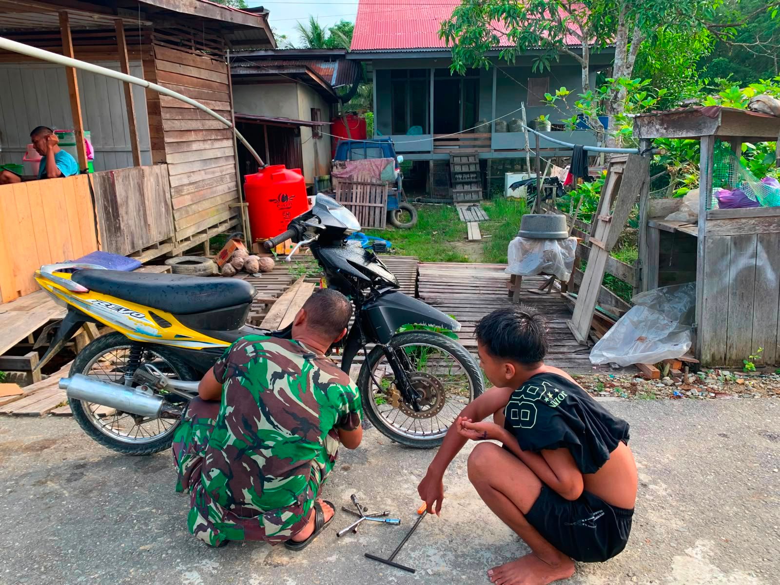 Datang Untuk Berbagi Keahlian, Sertu Yudha Purnomo Anggota Satgas TMMD Kodim 1206/Psb Perbaiki Motor Warga Desa Ulak Pauk yang Rusak