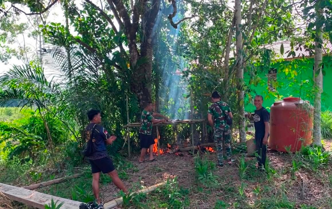 Di Sela-sela Kegiatan, Anggota Satgas TMMD Regtas Ke-129 Kodim 1206/Putussibau Bantu Warga Buat Salai Ikan