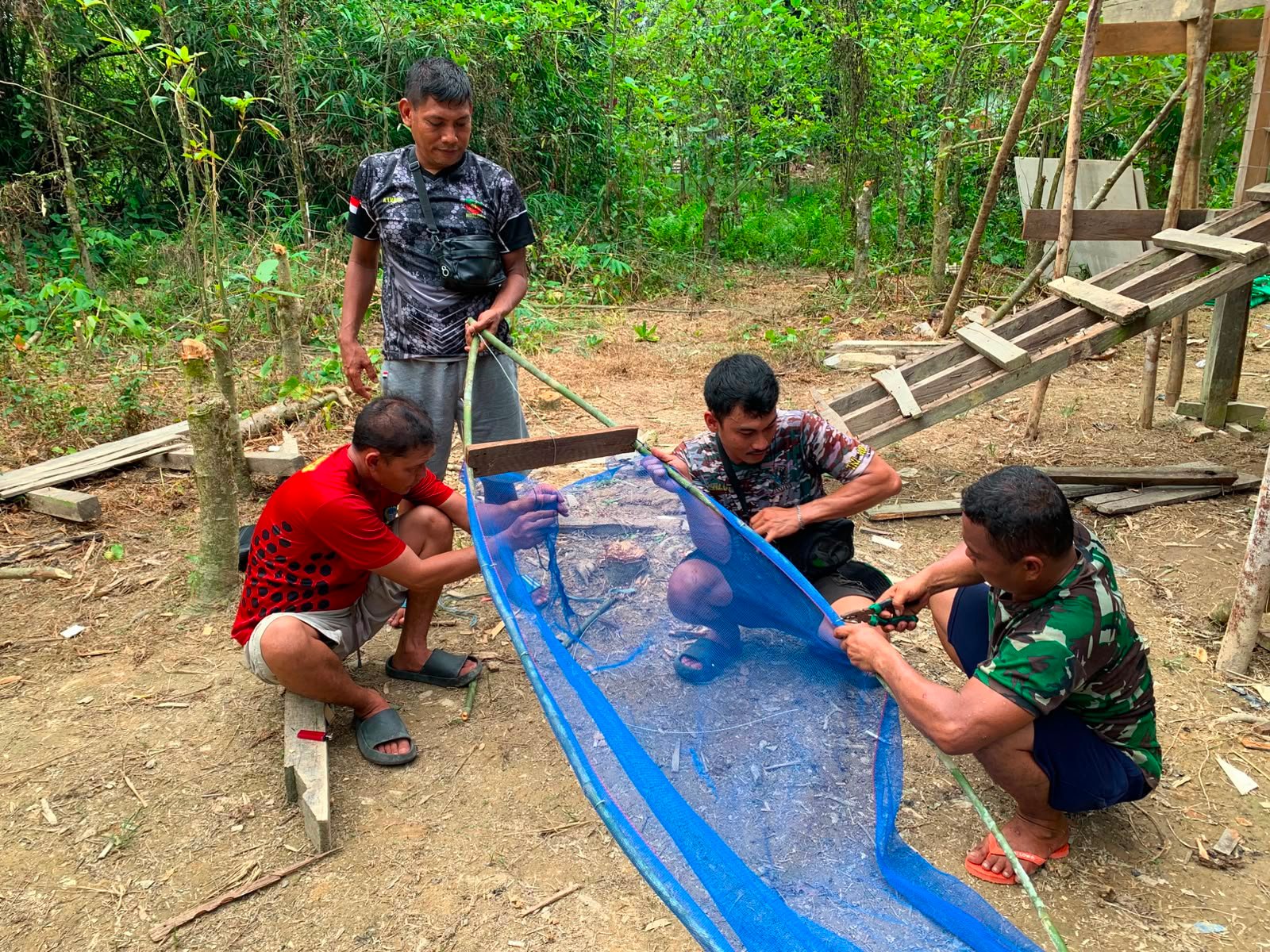 Jalin Keakraban Bersama Warga, Anggota Satgas TMMD Regtas Ke-129 Kodim 1206/Putussibau Bantu Warga Dusun Pala Pintas Buat Jaring Ikan