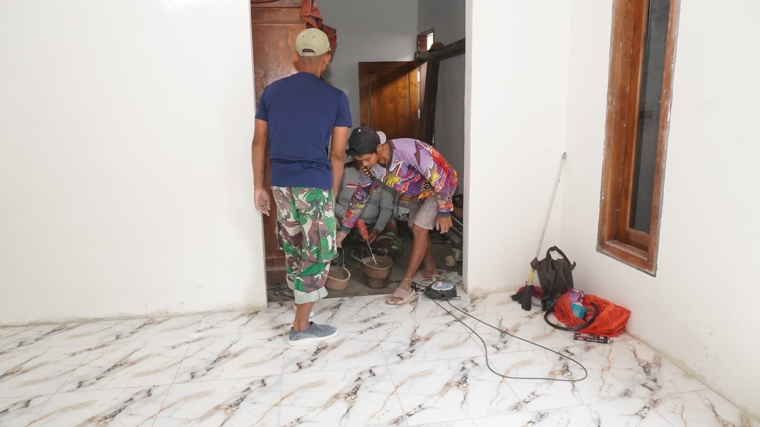Wujudkan Rumah Layak Dihuni, Satgas TMMD 129 Kodim 0812/Lamongan dan Warga Rampungkan Pemasangan Keramik Rumah Ibu Siswati