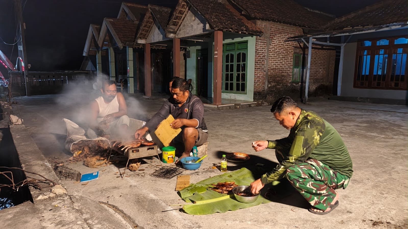Pererat Tali Silaturahmi, Hangatnya Keseruan Anggota Satgas TMMD 129 dan Warga Desa Tlemang Gelar Acara Bakar Ikan Bersama di Malam Hari