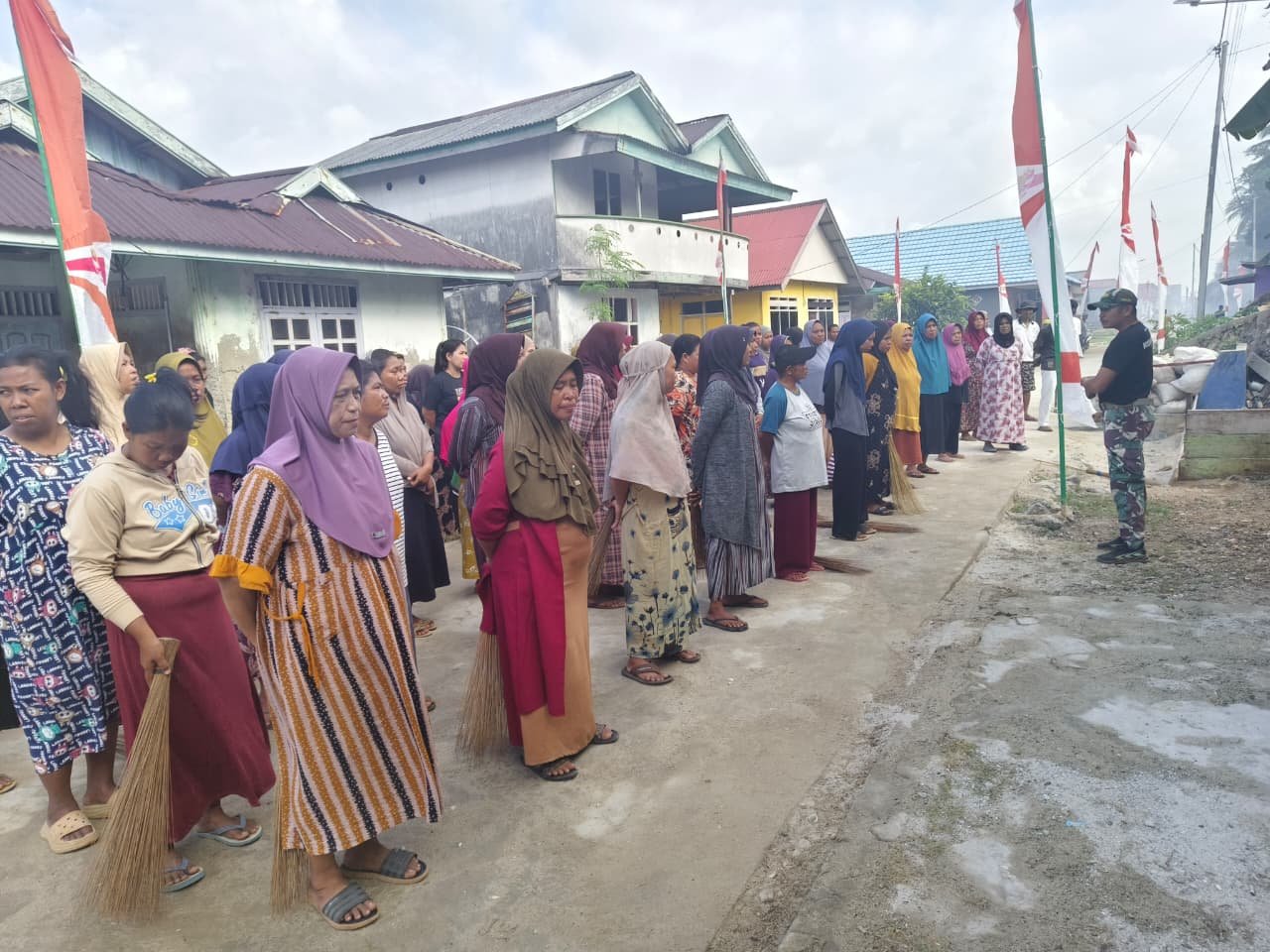 Ibu-Ibu Desa Polewali Bersama Satgas TMMD Bersihkan Lokasi Jelang Penutupan TMMD Ke-129