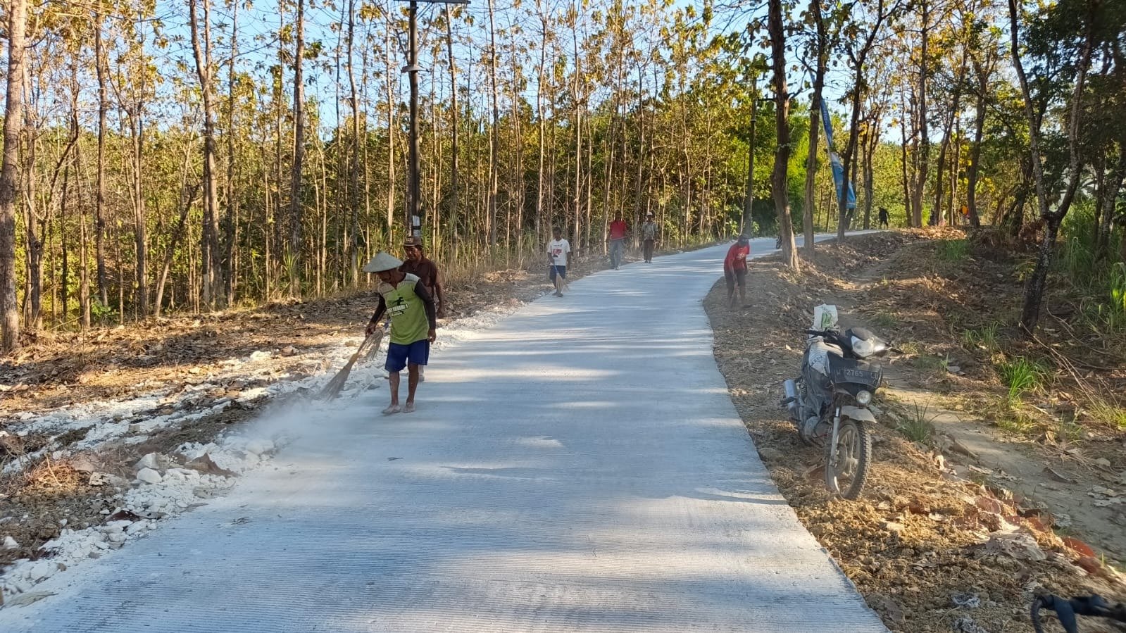 Wujud Rasa Syukur Atas Akses Jalan Baru, Warga Desa Tlemang Antusias Bersihkan Jalan Rabat Beton Menggunakan Sapu Lidi