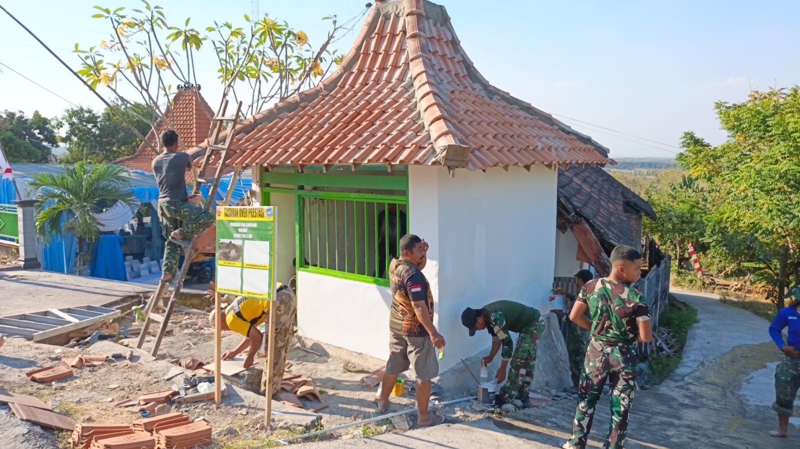 Tangan Terampil Serka Anom dkk Percantik Dinding Pos Kamling Desa Tlemang, Satgas TMMD 129 Kodim 0812/Lamongan Garap Sasaran Sentuhan Akhir