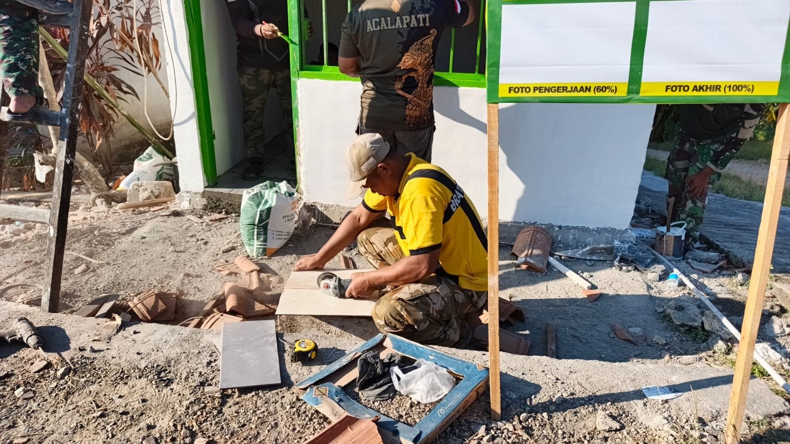 Bikin Poskamling Makin Megah dan Rapi, Tangan Terampil Serda Ali Anggota Satgas TMMD 129 Unjuk Ketelitian Potong Keramik