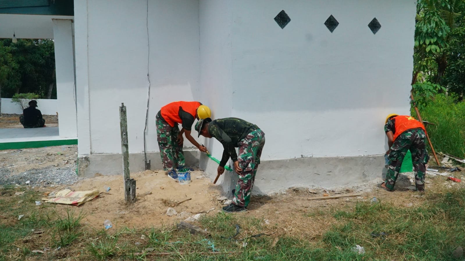 Tahap Finishing Musholla Darul Iman Terus Dimaksimalkan, Satgas TMMD Ke-129 Kerjakan Pengecatan Lis Pondasi