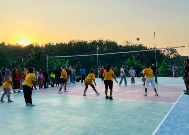 Pemandangan Sore nan Indah: Langit Cerah Iringi Emak-Emak dan Pemudi Asyik Bermain di Lapangan Voli Karya Satgas TMMD 129