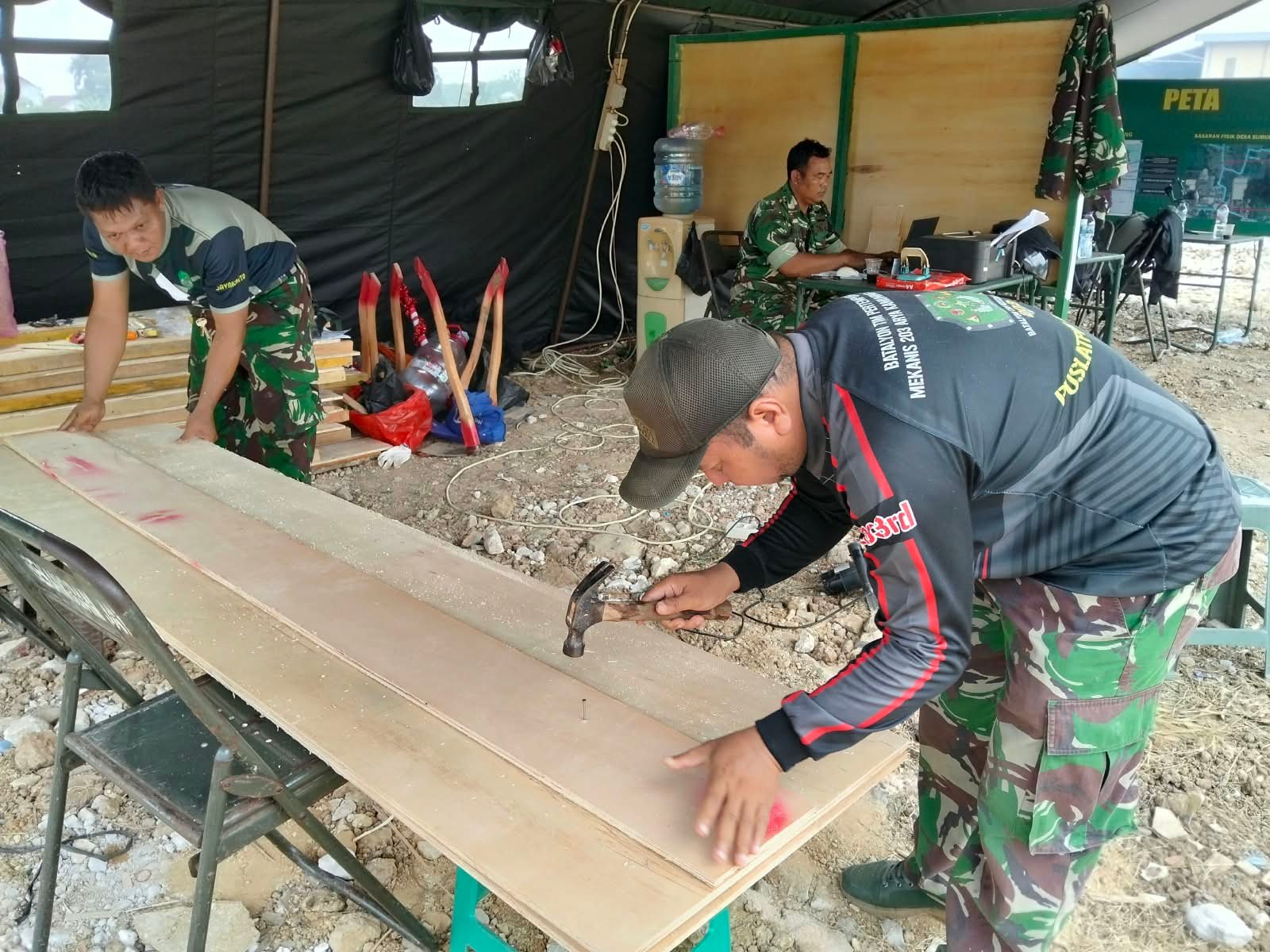 Pemotongan Triplek oleh Satgas TMMD untuk Kesiapan Proyek Infrastruktur Desa